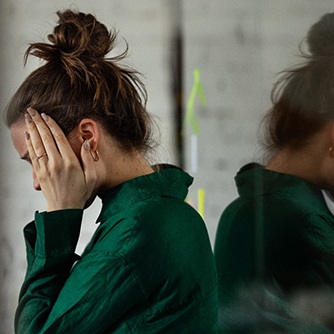 Woman in green shirt looking exhausted