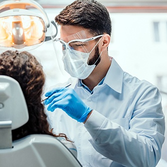 A dentist treating a patient in their dental chair
