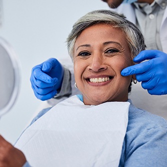 a smiling woman sitting in a dental chair