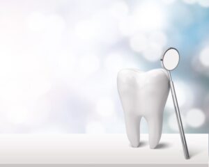 Tooth with dental mirror leaning on it.